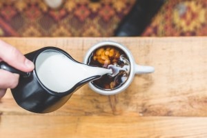 Cream being poured into mug of coffee